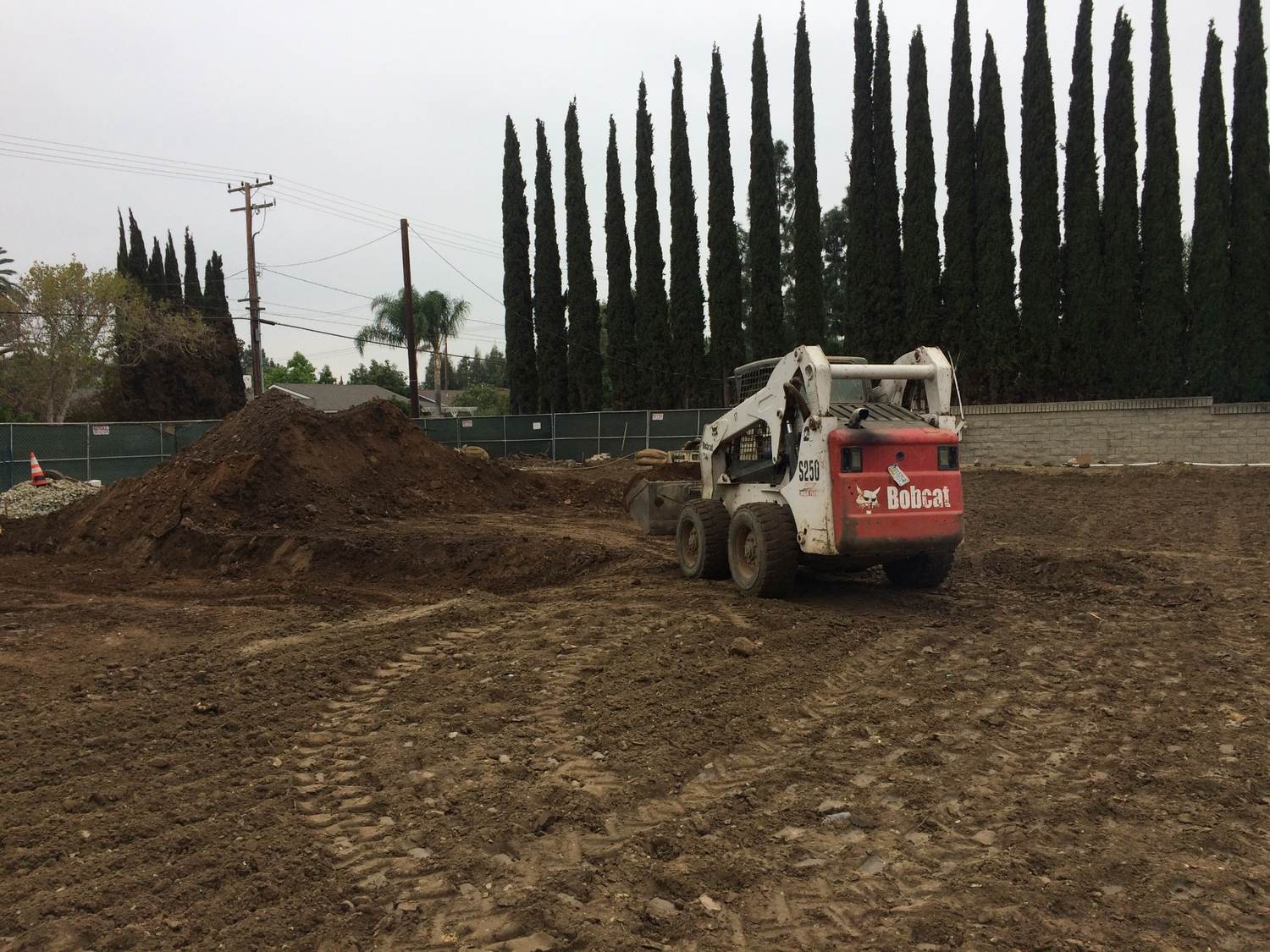 Skid-steer grading the building pad at the Villa Park site