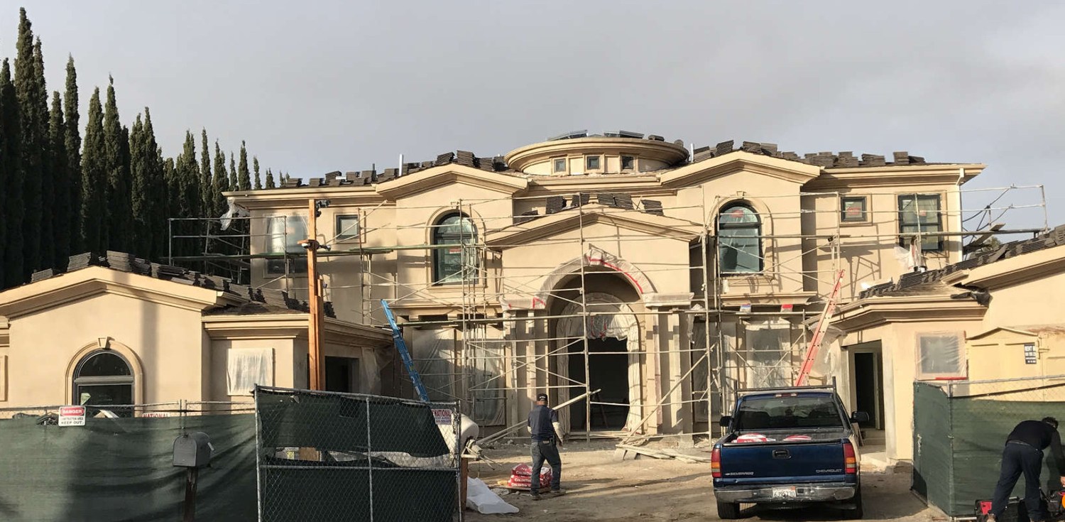 Three-coat stucco work on the exterior with scaffolding