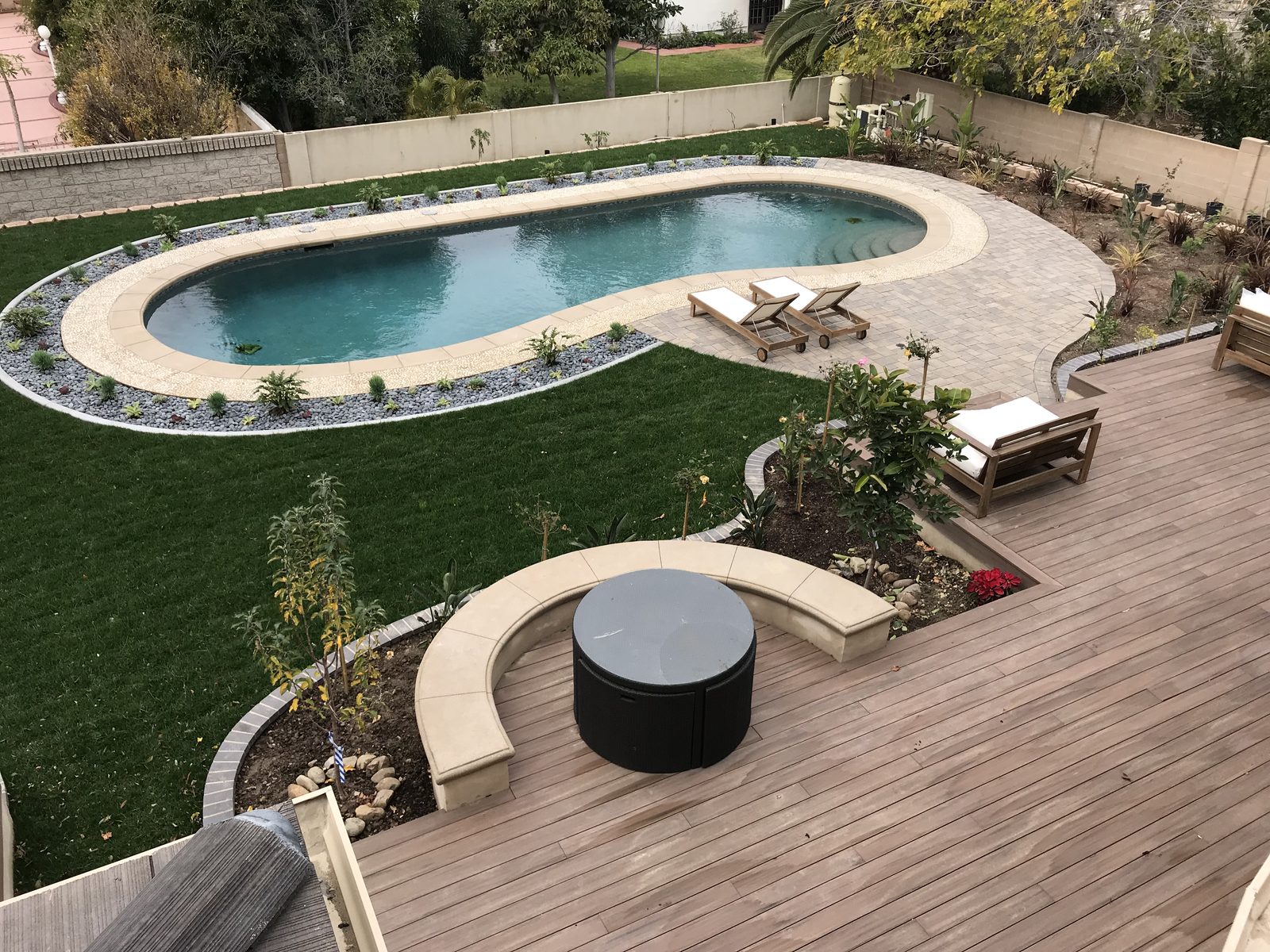 Luxury backyard landscaping, pool, and custom wood decking by Newport Construction Group in Villa Park, CA