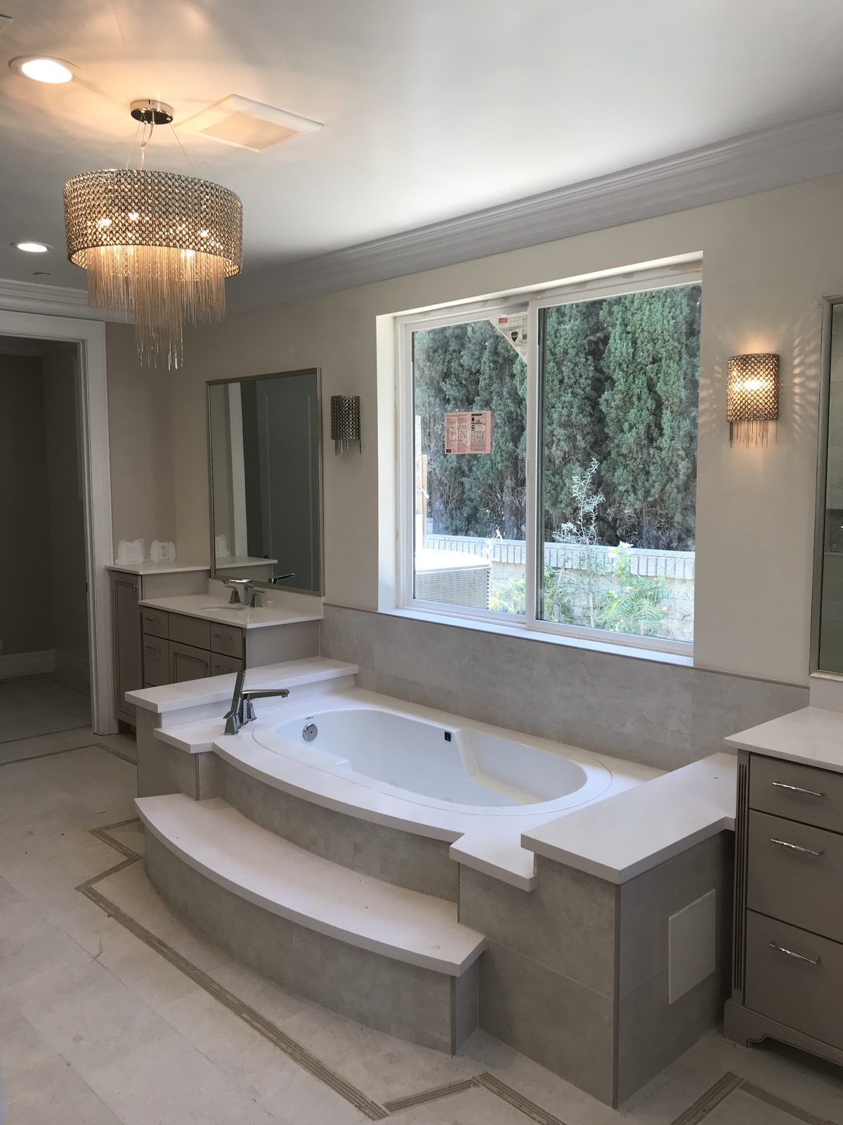 High-end primary bathroom renovation featuring a tiered soaking tub by Newport Construction Group